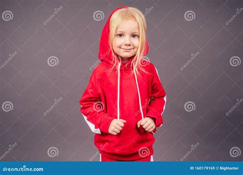 Petite Mannequin Blonde Aux Yeux Bleus En Costume De Sport Rouge Posant Dans Le Studio Sur Fond