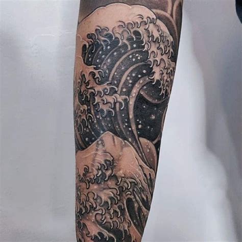 A Man S Arm With An Ocean Wave Tattoo On It