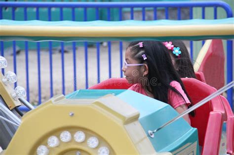 5 Year Old Brunette Girl With Glasses Has Fun On An Amusement Park Ride Spending Her Summer