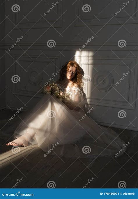 Beautiful Natural Redhead Girl Bride With Nude Makeup Wearing A White Dress Holds A Wedding