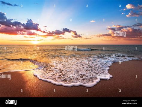 Colorful Ocean Beach Sunrise With Deep Blue Sky And Sun Rays Stock