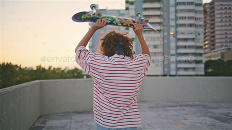 Girl Skater Carrying Skateboard Walking On Building Roof Skateboarder