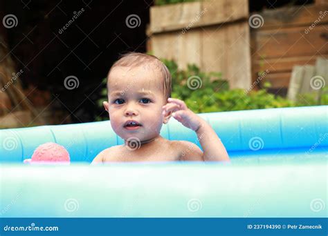 Petit Gar On Mignon Dans La Piscine Gonflable Bleu Jouant Avec Le