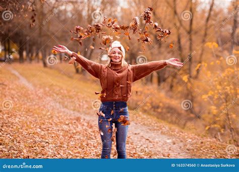 Fijne Blonde Meid In Een Witte Gebreide Hoed Bruine Gebreide Trui Blauwe Jeans Gooien