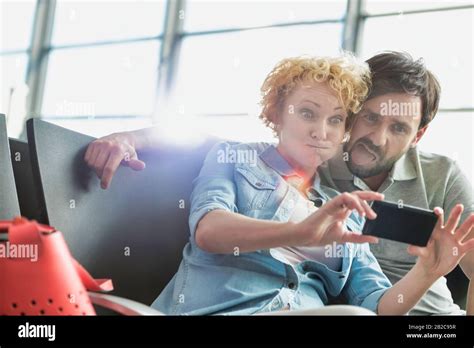 Portrait Of Mature Couple Taking Selfie While Waiting For Boarding In Airport Stock Photo Alamy