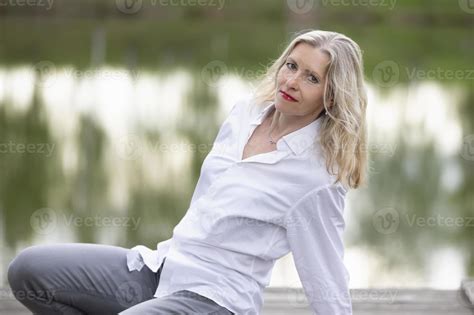A Beautiful Middle Aged European Woman Fifty Year Old Blonde Woman In A White Shirt On The