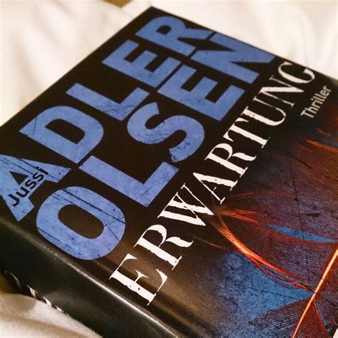 a book sitting on top of a bed next to a white blanket and pillow cover