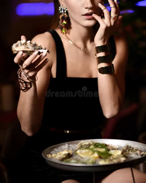 Beautiful Fashion Brunette Woman In Expensive Interior Restaurant Eat Oysters Stock Photo
