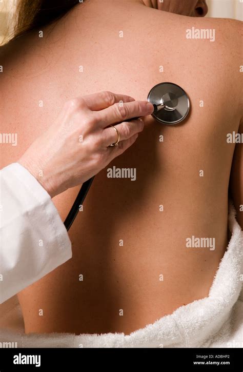 Woman Doctor Examines Nude Female Patient With Stethoscope Held To Back Stock Photo Alamy