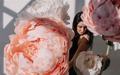 Brunette Woman Posing With Giant Flowers By Stocksy Contributor Liliya Rodnikova Stocksy
