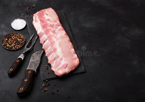 Fresh Raw Pork Ribs On Chopping Board And Vintage Meat Fork And Knife