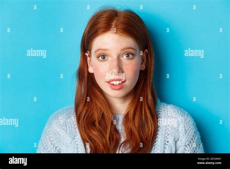 Headshot Of Cute Redhead Girl With Freckles Looking Hopeful And Innocent At Camera Standing