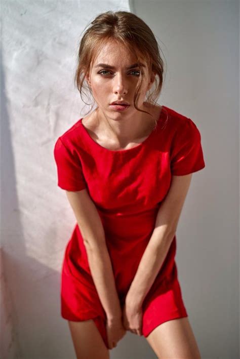 A Woman In A Short Red Dress Posing For A Photo With Her Hands On Her Hips