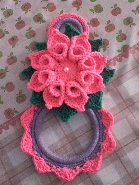 Three Crocheted Flowers Are Sitting On Top Of Each Other One Is Pink