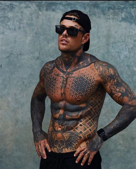 A Man With Tattoos On His Chest And Arms