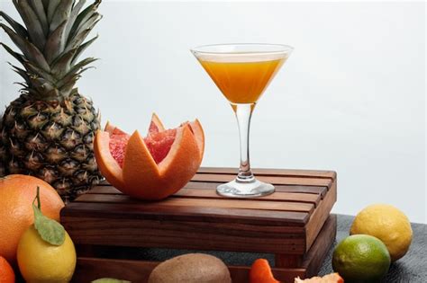 Вид сбоку на апельсиновый сок в стекле и нарезанный грейпфрут на ...