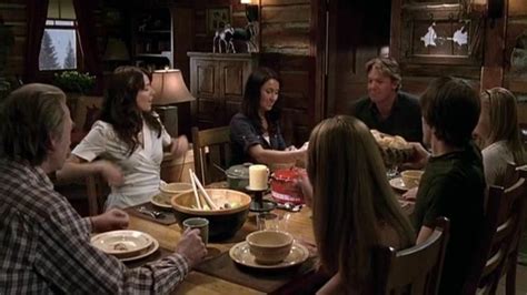 A Group Of People Sitting Around A Wooden Table