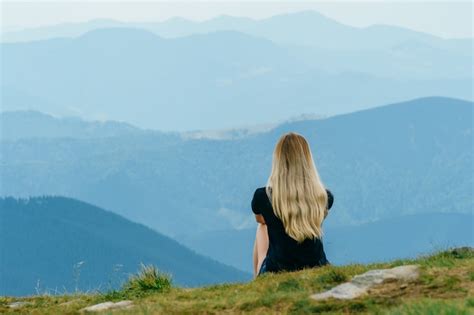 Premium Photo Blonde Girl Sitting In Mountains And Enjoying Landscape