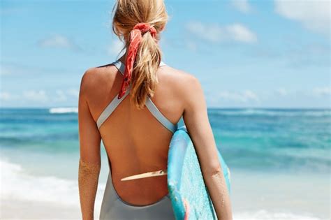 Femme Blonde Avec Planche De Surf Sur La Plage Photo Gratuite