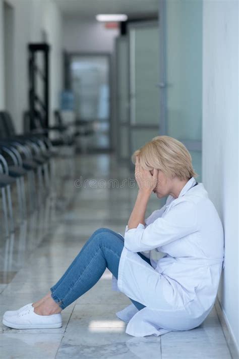 Tired Blonde Female Doctor Sitting On Floor Covering Her Face Stock Photo Image Of Health
