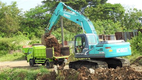 Kobelco Sk Excavator Moving Dirt With Dump Trucks Youtube