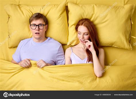 Happy Couple Lying In Bed Under Duvet After First Sex Experience Man Is Surprised By Skills Of