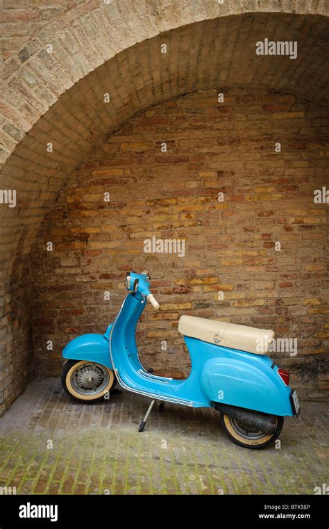 Baby Blue Vespa Parked In A Stone Archway In Urbino Le Marche Italy