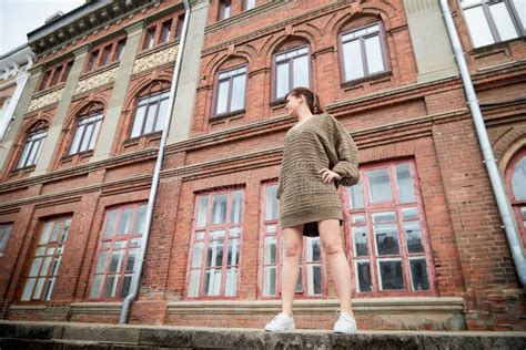 Brunette Divertida Linda Chica Cerca De La Pared Con Ladrillo Rojo En La Parte Central De La