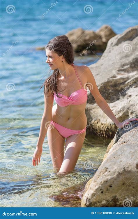 Mujer Joven En Bikini Rosado En La Costa Rocosa Foto De Archivo Imagen De Rocoso Lejos 133610830