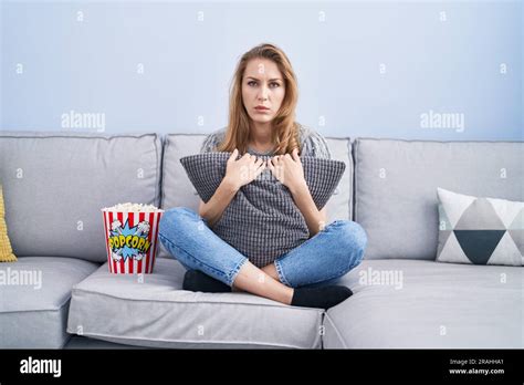 Belle femme blonde regardant la télévision assis sur le canapé déprimé et s inquiéter de la