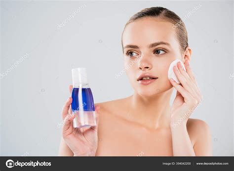 Naked Woman Holding Bottle While Applying Toner Cotton Pad Isolated Stock Photo By IgorVetushko
