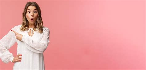 Fasciné Et Excité Une Fille Caucasienne Blonde Curieuse En Robe Blanche A L air Intriguée Par