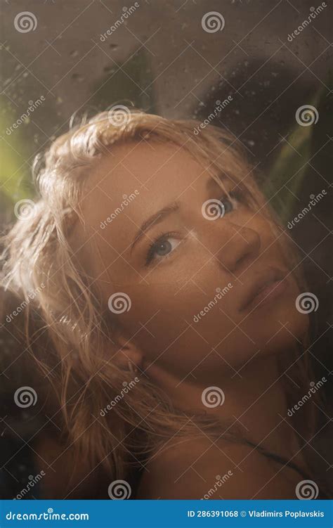 Portrait Of An Enchanting Blonde In A Black Swimsuit Behind A Shower Glass Stock Photo Image