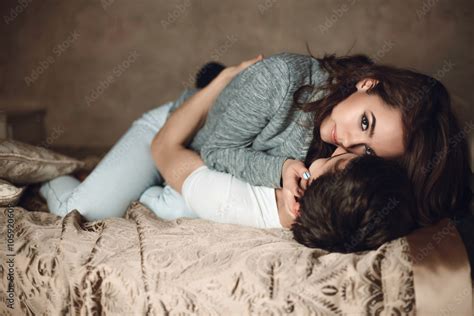 Beautiful Brunette Girl Lies On Top On Guy On The Bed Stock Photo Adobe Stock