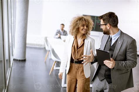 Young multiethnic entrepreneurs standing together and talking in the