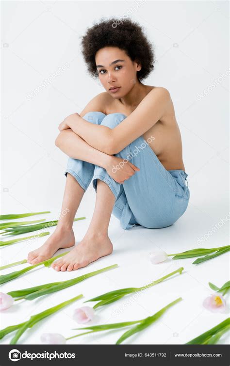 Barefoot African American Woman Naked Shoulders Sitting Flowers Grey Background Stock Photo