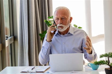 Premium Photo Mature Businessman Working On Laptop And Talking On Cellphone Handsome Mature