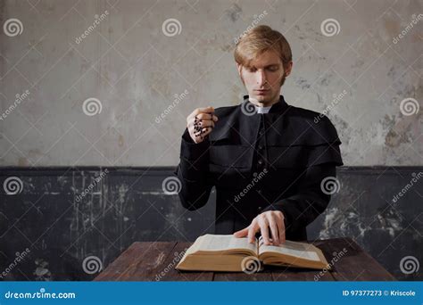 Portrait Of Handsome Young Catholic Priest Praying To God Stock Image