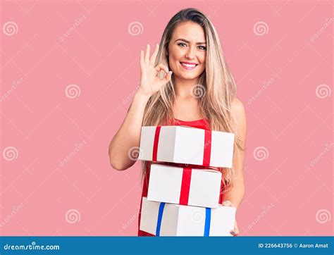 Jeune Belle Femme Blonde Tenant Des Cadeaux D Anniversaire Faire Ok Signe Avec Des Doigts