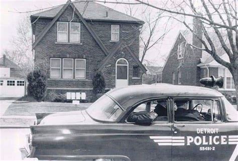 An Old Black And White Photo Of A Police Car Parked In Front Of A House