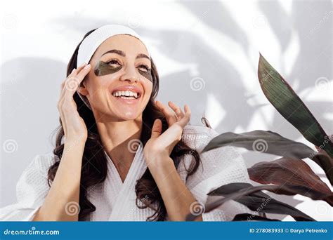 Une Femme Souriante En Peignoir Blanc S Occupe De Sa Peau Et Colle Des Taches Noires Sur Son