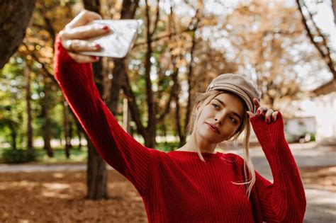 Jolie Blonde Faisant Selfie Dans Le Parc D Automne Charmante Dame En Pull Rouge Et Chapeau
