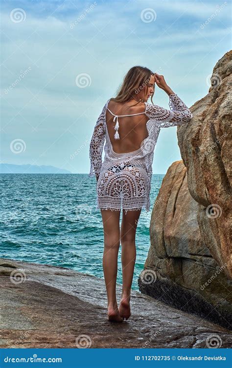 Beautiful Girl With Blonde Hair In A White Lingerie Wonderful Posing On The Ocean Stones Beach