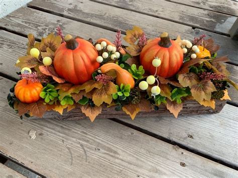 An Arrangement Of Pumpkins Leaves And Berries On A Wood Planked Table Top