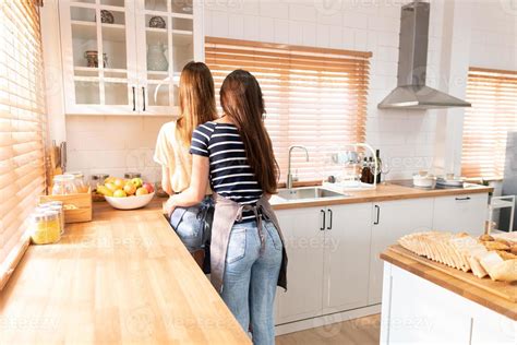Behind Of Two Girlfriends Or A Lesbian Couple Standing In Kitchen Lesbian Couple Standing In A
