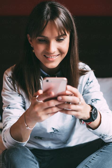 Happy Brunette Female Using Smartphone By Stocksy Contributor Viktor Solomin Stocksy