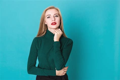 Belle Femme Blonde Sexy Debout Sur Un Fond Bleu Photo Premium