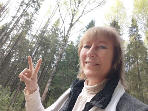 The Blonde Girl Tourist Takes A Selfie In Nature In The Forest On A Hike Or Trip The Pretty