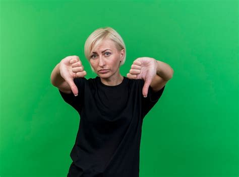 Femme Slave Blonde D Ge Moyen Non Satisfait Montrant Les Pouces Vers Le Bas Isol Sur Un Mur