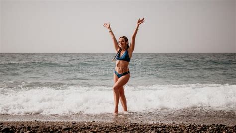 A Tourist Woman In Blue Bikini On Beach Enjoys The Turquoise Sea During